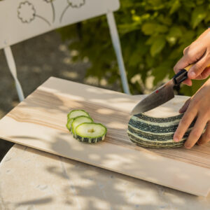Planche à découper contemporaine, grand modèle, découpe de courgette dans le jardin.